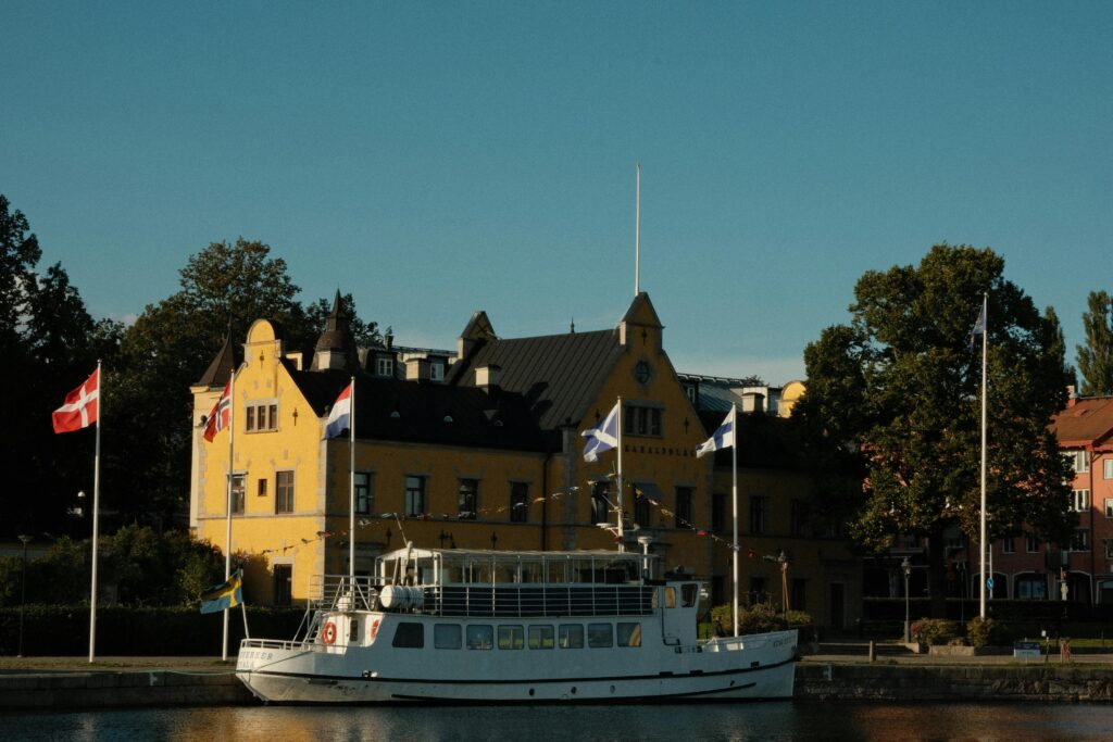 A picturesque view of a canal with a boat and a historic building, captured on a sunny day.